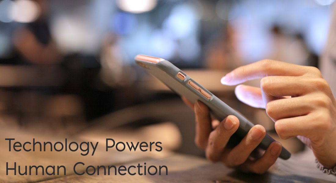 A woman's hands holding a cell phone Text: Technology Powers Human Connection
