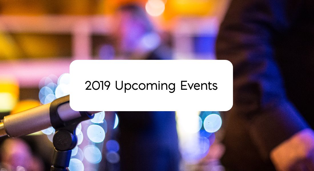Blurred background with a person walking past a microphone Text: 2019 Upcoming Events